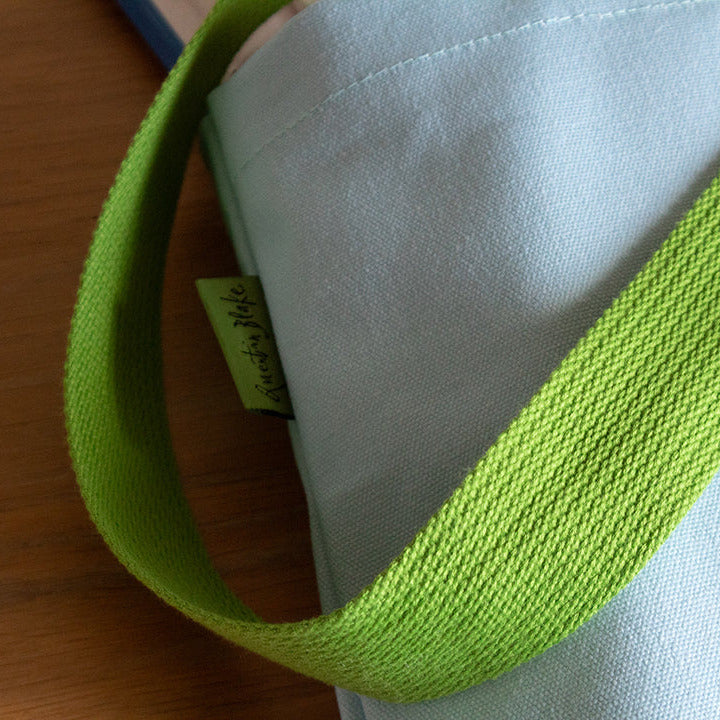 Close-up of a green strap on a white surface with a wooden background